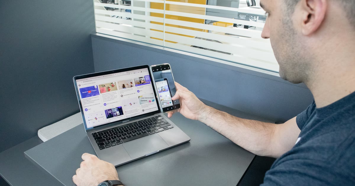 Persoană care verifică un site pe laptop și telefon