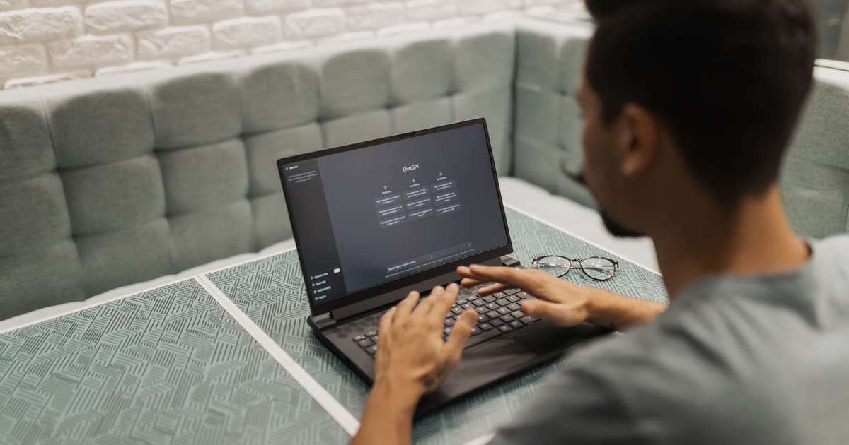Persoană care folosește ChatGPT pe laptop la birou