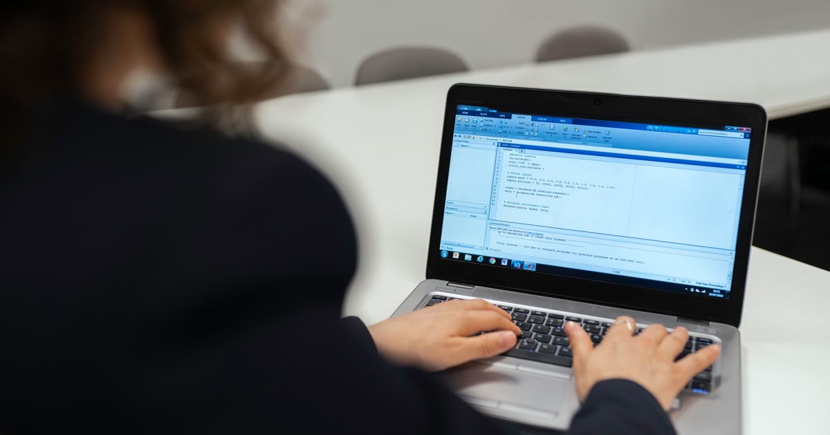 Persoană care optimizează codul unei pagini pe laptop