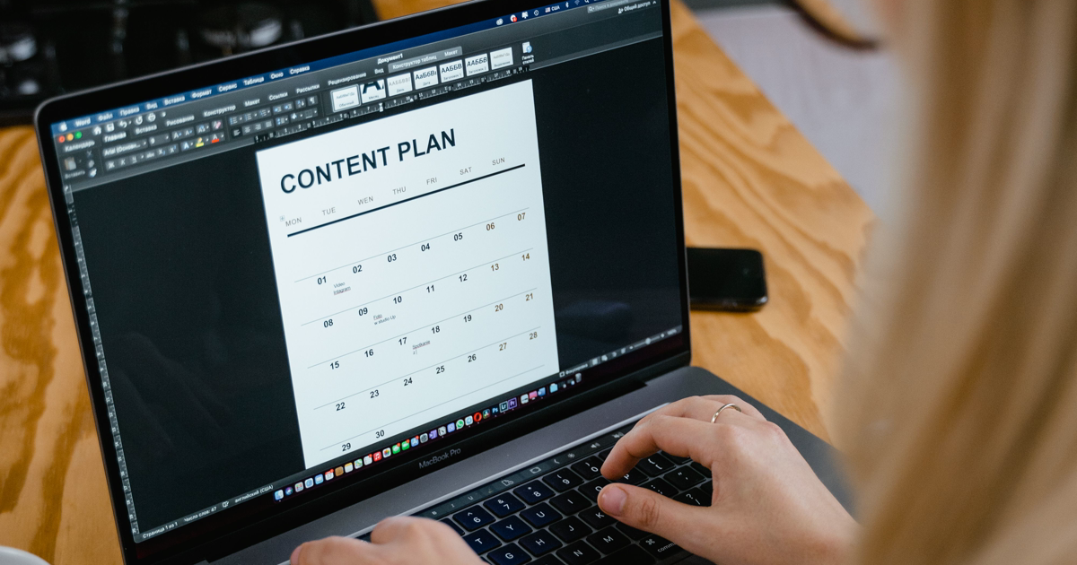 Persoană care pregătește un plan de conținut pe laptop